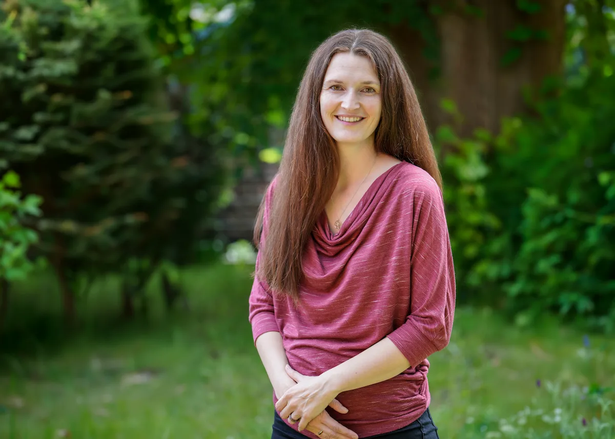 Jeanette Kircheis, Diplom-Psychologin und systemische Beraterin, lächelt im Grünen – Kennenlerngespräch bei Ressourcensicht in Tharandt